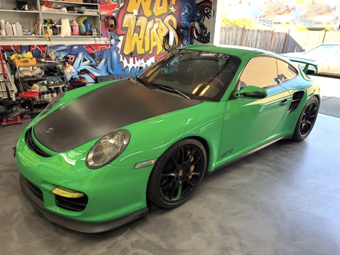 A green Porsche GT2 with paint protection film applied